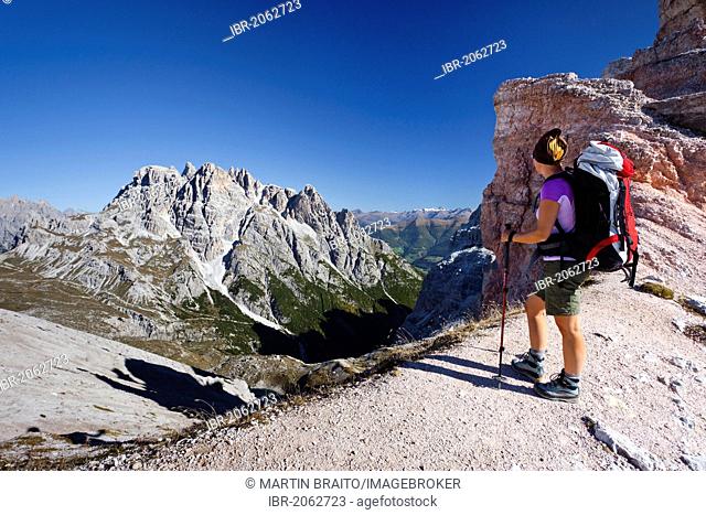 Hikers below the Pian di Cengia ridge, climbing Mt Paterno, Mt Punta dei Tre Scarperi in the back, Val Sassovecchio Valley below, Sesto, Sexten