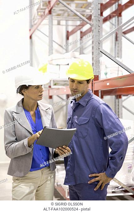 Female manager speaking with warehouse worker
