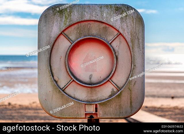 A faded lifebuoy with blurry background, seen in Seascale, Cumbria, England, UK
