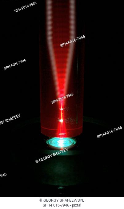 Laser and ruby rod. Experiment with a green laser beam being used to induce red luminescence in a rod of artificial ruby