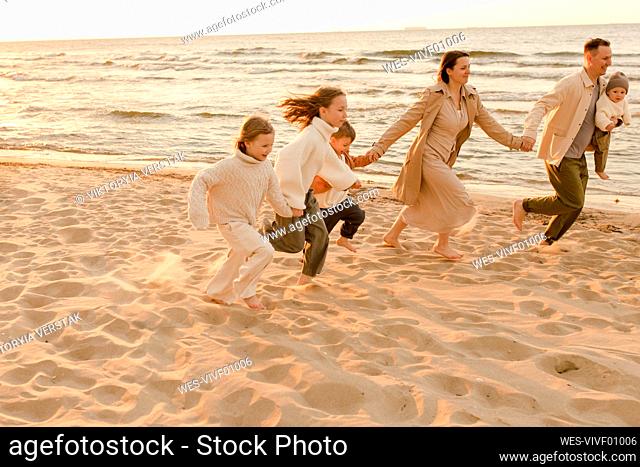 Happy family running and enjoying at beach