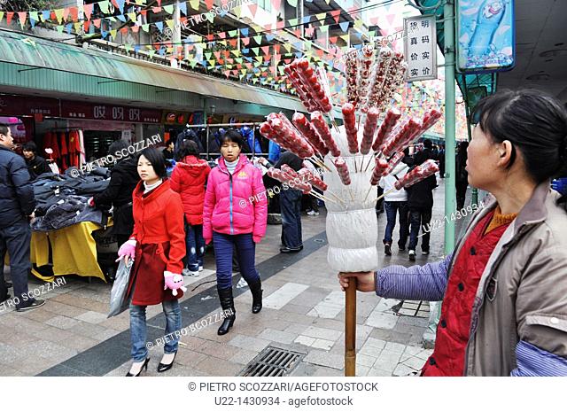 Dongguan (China): a candied fruit seller at the clothes market in the Changping District
