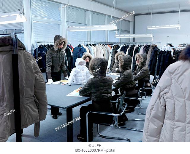 Product developers inspecting coat