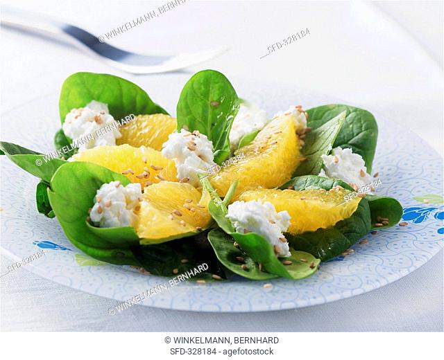 Spinach salad with fresh goat's cheese, orange segments & sesame