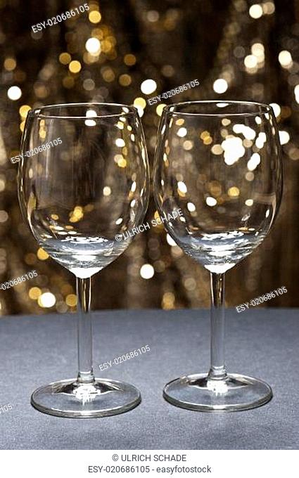 White wine glasses in front of glitter background