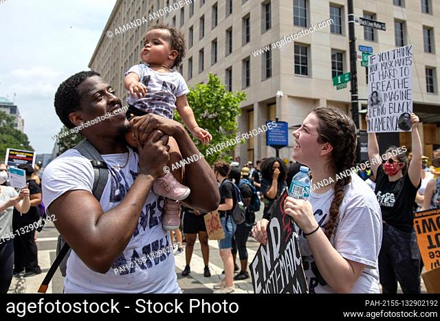 Nyron Dancy holds up his 1-year-old daughter Ny’omi Dancy, while her mother Kendal Gonthier looks on during a march against police brutality and racism in...