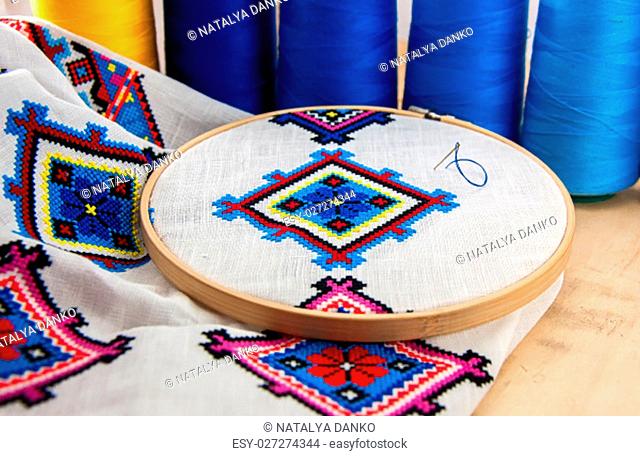 Traditional Slavic geometric pattern embroidered stitch cross on a white canvas with colored thread
