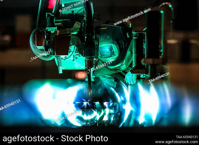 RUSSIA, SVERDLOVSK REGION - DECEMBER 19, 2023: A welder uses a robotic installation to manufacture a Lastochka ES104 high-speed electric train at the Ural...