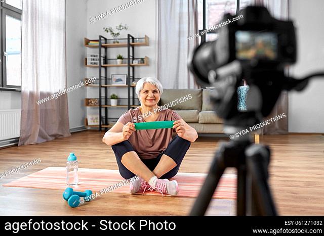 woman or fitness blogger with camera at home
