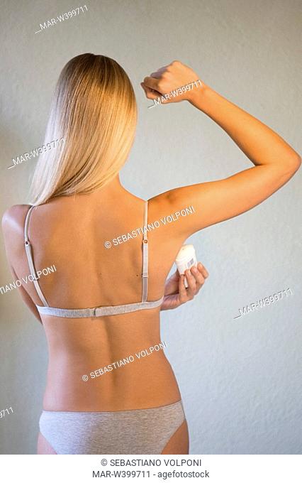 young woman applying deodorant