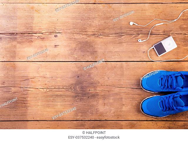 Running shoes and mp3 player on a wooden floor background