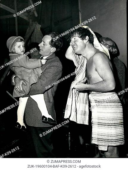 1965 - A rub down for a 'Shipwrecked' Kenneth More: Search More, 2-year-old daughter of Kenneth More, watches while her father has a rub down after the...