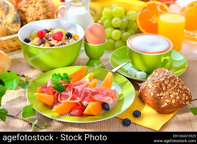 Reichlich gedeckter Frühstückstisch mit Schinken und Melone - Laid breakfast table with melon and ham
