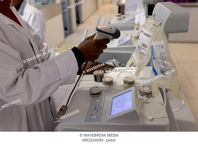 Laboratory technician scanning bar code of plasma bags