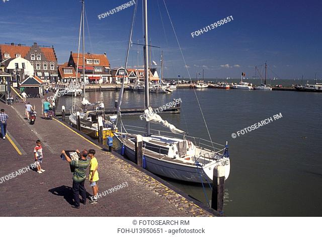 Holland, Volendam, Netherlands, Noord-Holland, Europe, People along the waterfront on the harbor on Markermeer in the town of Volendam