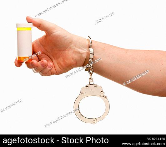 Handcuffed man holding blank medicine bottle isolated on a white background