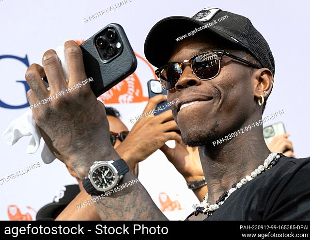 12 September 2023, Hesse, Frankfurt/Main: Dennis Schröder, captain of the national basketball team, films the team's reception with his cell phone