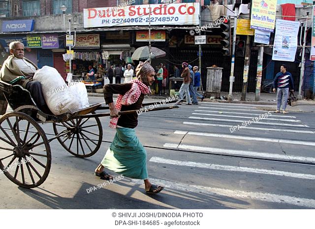 man carrying passenger on hand rickshaw at West Bengal India
