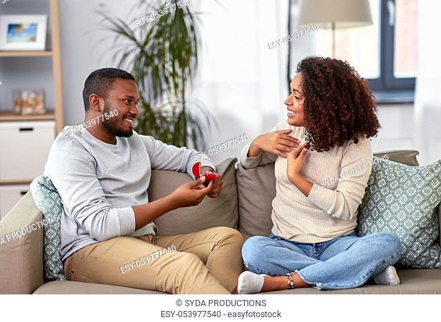 african american man giving woman engagement ring