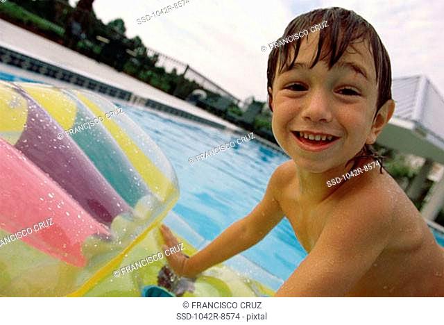 Portrait of a boy on a raft in a swimming pool