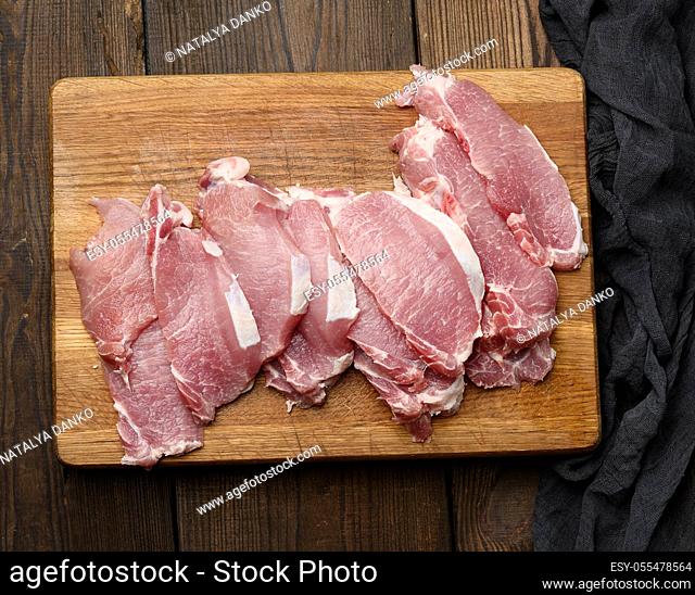 sliced pork tenderloin on a wooden cutting board, top view