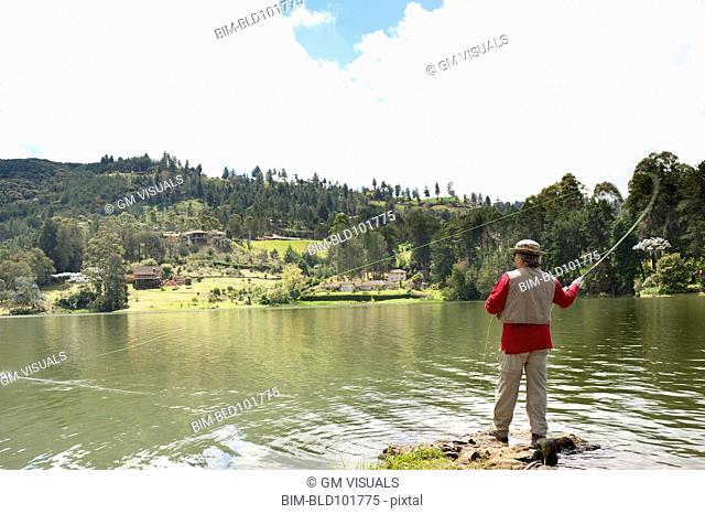 Hispanic man fishing in lake