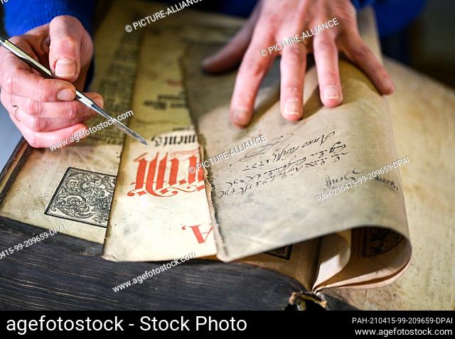 13 April 2021, Berlin: In the paper workshop Friedrichshagen a bible, ""The whole Holy Scripture"", from the year 1737 is repaired
