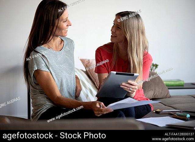Smiling businesswomen working on digital tablet