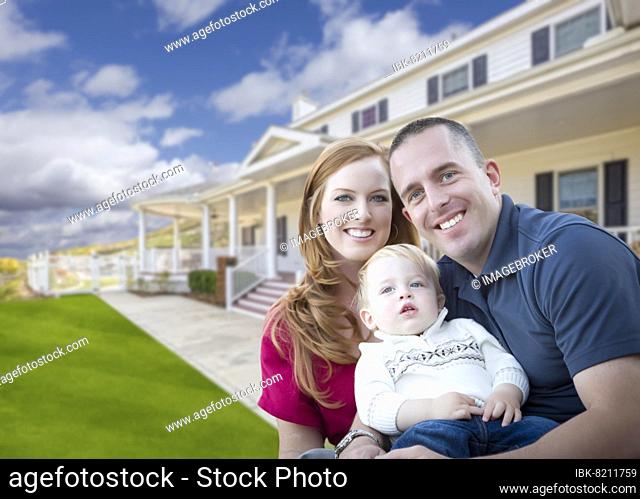 Happy young military family in front of their beautiful house