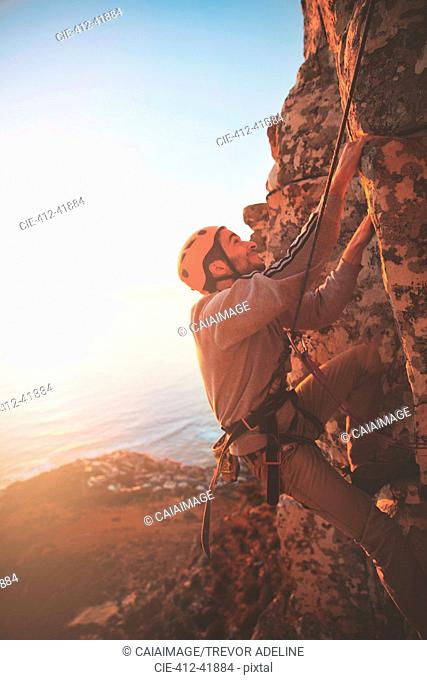 Male rock climber scaling rock