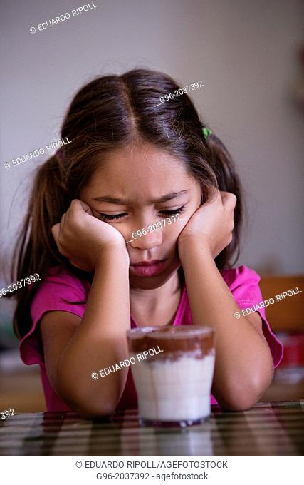 Angry girl in front of a glass with milk