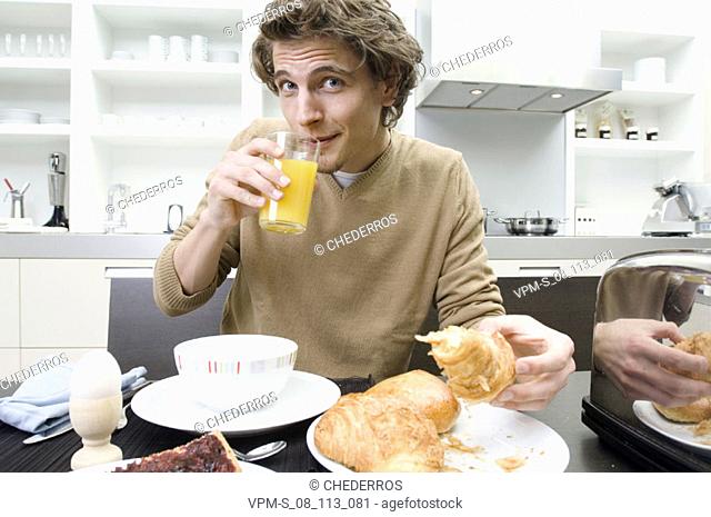 Portrait of a young man sitting at the breakfast table