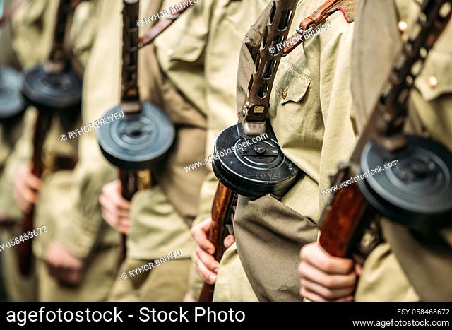 Re-enactos Dressed As Russian Soviet Soldiers Of World War II Holds Sub-machine Guns Weapon In Hands And Standing Order