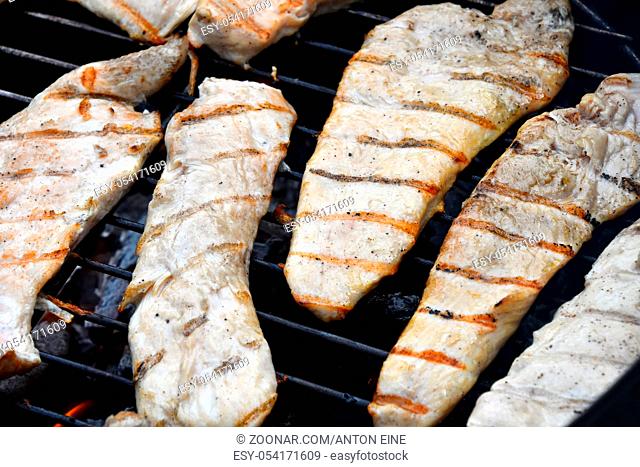 Chicken or turkey meat barbecue steak ready cooked grilled on bbq smoke round grill, close up
