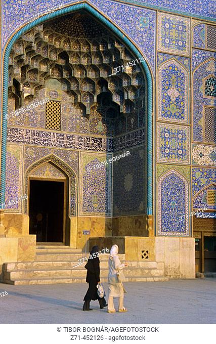 Women passing by Sheykh Lotfollah Mosque in Emam Khomeini Square. Esfahan, Iran