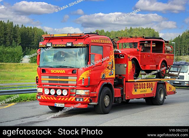 Scania flatbed tow truck of Hinaus Andersson Oy carrying a vintage fire truck. Salo, Finland. August 6, 2015