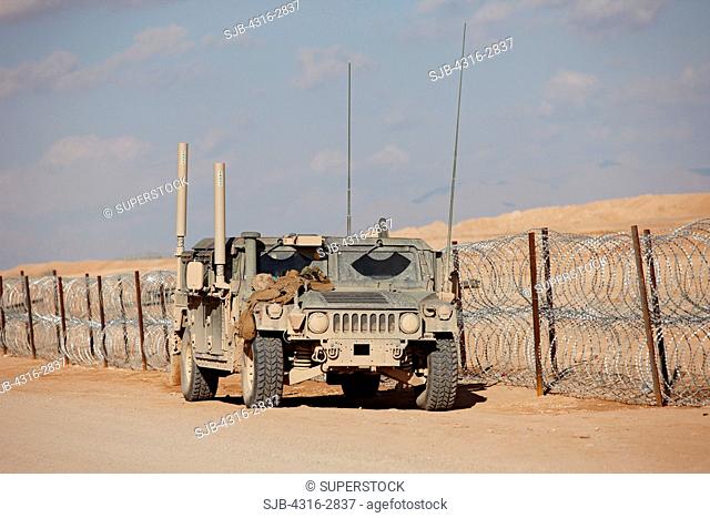 A U.S. Marine Corps HMMWV, or Humvee, parked next to concertina wire, Camp Bastion, Helmand Province, Afghanistan