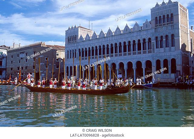 Grand Canal. Regatta storica, festival. Long boat with oarsman in uniform. Decorated prow and stern. Crowd