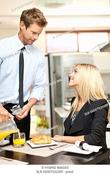 Man pouring juice at breakfast