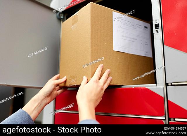 woman putting box to automated parcel machine
