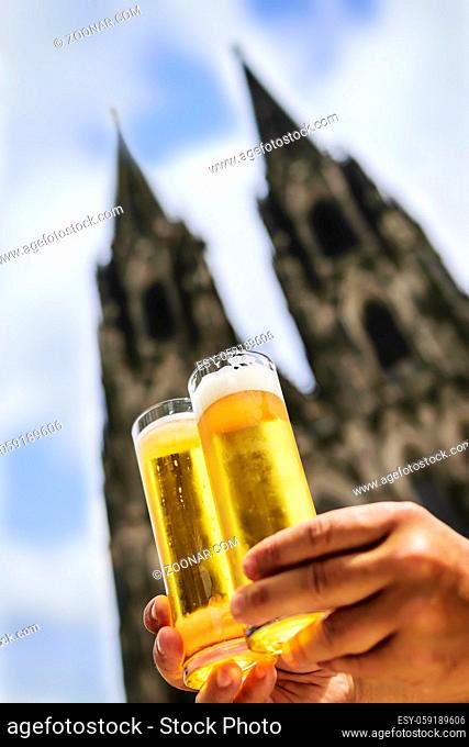 Two glasses of beer named Koelsch with cathedral of Cologne in background, Germany