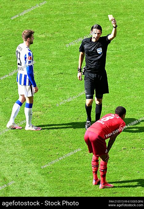 15 May 2021, Berlin: Football: Bundesliga, Hertha BSC - 1. FC Köln, Matchday 33 at Olympiastadion. Referee Deniz Aytekin shows Cologne's Ismail Jakobs the...