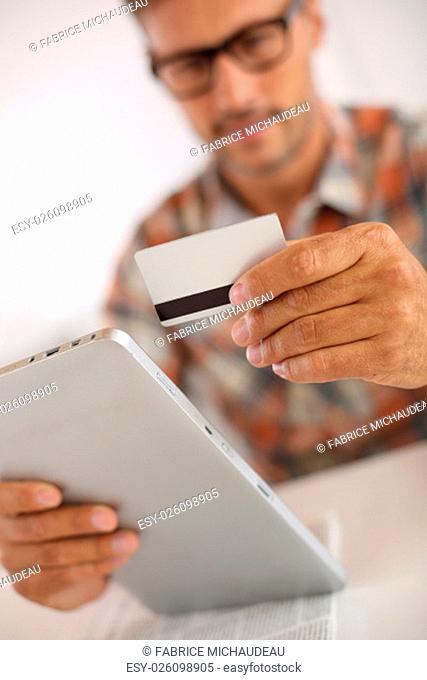 Trendy guy doing online shopping with tablet