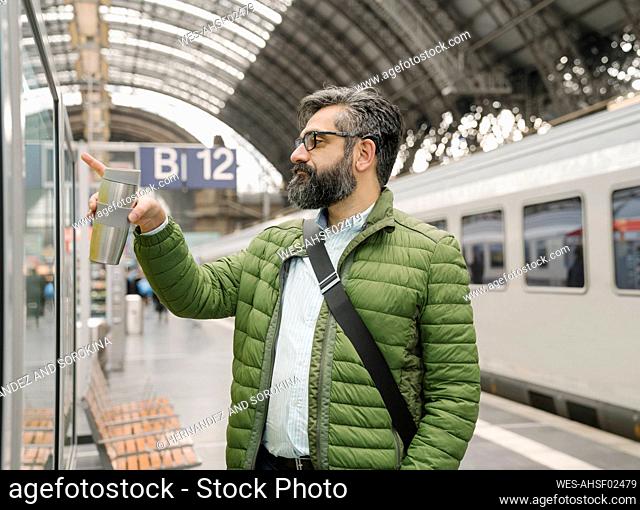 Man checking the timetable at the train station