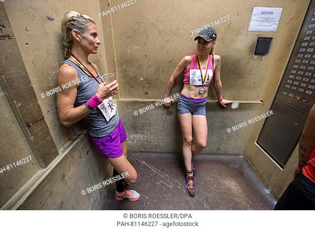 Two exhausted participants take the freight elevator down after crossing the finish line on the 62nd floor of the Messeturm tower in Frankfurt am Main, Germany