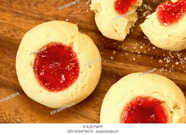 Thumbprint Christmas cookies filled with strawberry jam, photographed overhead with natural light (Selective Focus, Focus on the top of the cookies)