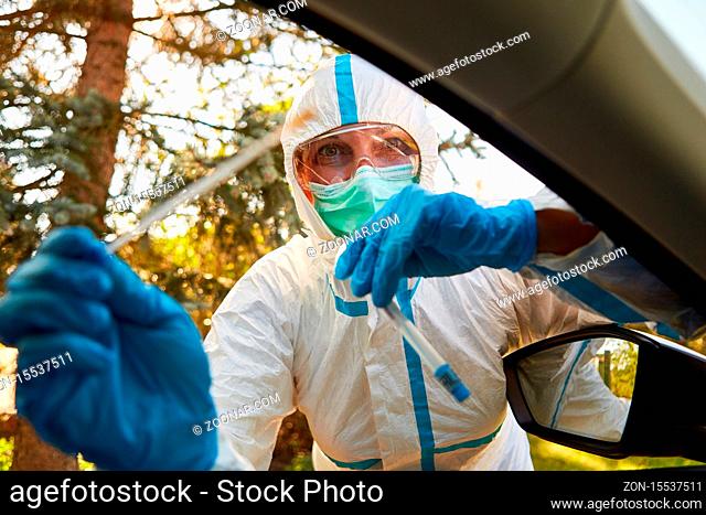 Containment Scout vom Gesundheitsamt hält Abstrich für Coronavirus Schnelltest in Drive-In Teststation