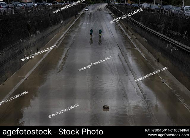 18 May 2023, Italy, Faenza: Two workers inspect an underpass which is feared to collapse following severe flooding. Italy's Emilia-Romagna region saw...