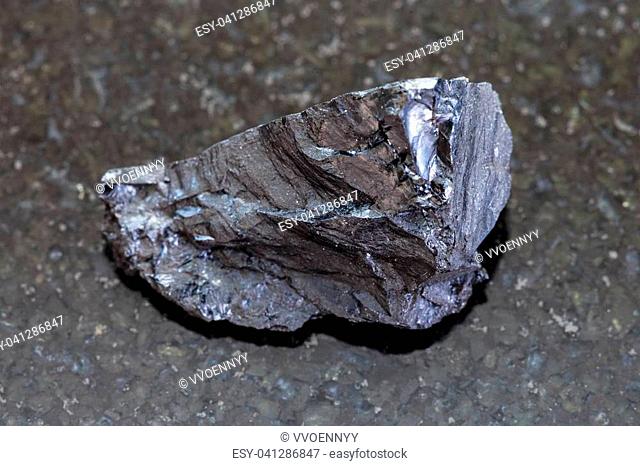 macro shooting of natural mineral rock specimen - rough Anthracite coal on dark granite background