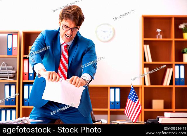 Young handsome politician sitting in office